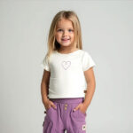 Crèmekleurig baby t-shirtje met lavendelkleurig hartje, pofmouwtjes en drukknoopsluiting uit de Frogs and Dogs collectie.