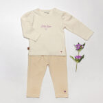 Crèmekleurig baby t-shirtje met lange mouw, tekst ‘Little Love’, lila hartje en pofmouwtjes uit de Frogs and Dogs collectie.