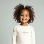 Crèmekleurig baby t-shirtje met lange mouw, tekst ‘Little Love’, lila hartje en pofmouwtjes uit de Frogs and Dogs collectie.