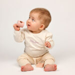 Crèmekleurig baby t-shirtje met lange mouw, tekst ‘Little Love’, lila hartje en pofmouwtjes uit de Frogs and Dogs collectie.