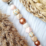 Speenkoord Cato in roze en koper met bloemkralen en houten clip van Happy by Lies