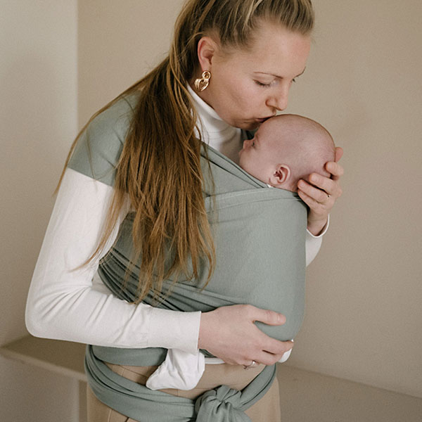 Ouder draagt baby in draagdoek, warm en comfortabel dichtbij