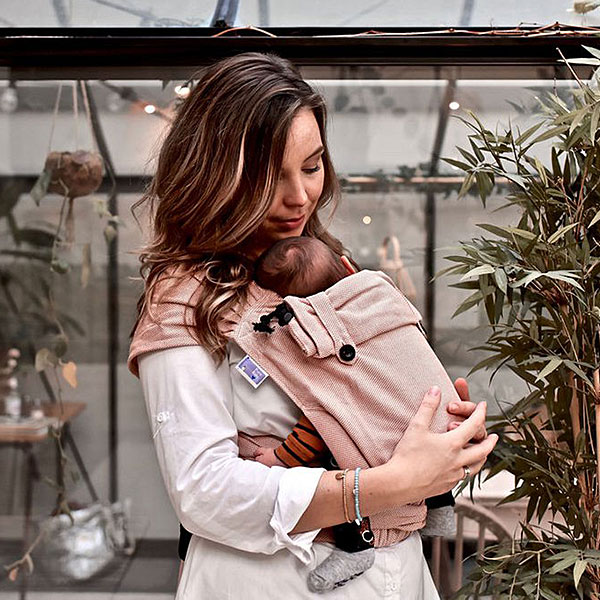 Ouder draagt baby in draagzak, warm en comfortabel dichtbij