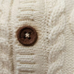 Showmodel Frogs and Dogs gebreid vestje Off White met kabelmotief en lichte verkleuring bij houten knoopjes