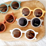 Ronde kinderzonnebril van Rammelaartje in effen taupe met UV400 bescherming