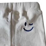 Frogs and Dogs baby bikerpants beige uit de Happy with You collectie met blauw koordje en geborduurde smiley achterop