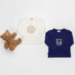 Frogs and Dogs Play All Day baby & peutershirt Emblem White Alyssum met rond embleem en beertje