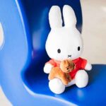 Witte Nijntje knuffel met rood jurkje die haar bruine hondje Snuffie vasthoudt, van Bon Ton Toys.