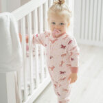Roze Frogs and Dogs baby onesie met paardenprint en roze manchetten.