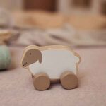 Houten speelgoedauto in de vorm van een lammetje met wieltjes van FSC gecertificeerd hout