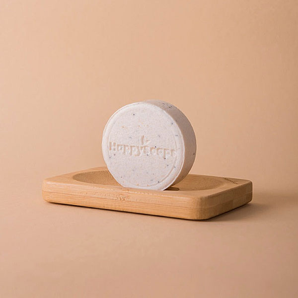 Witte HappySoaps Totally Coco Nuts Shampoo Bar met subtiele stukjes kokos en clean background