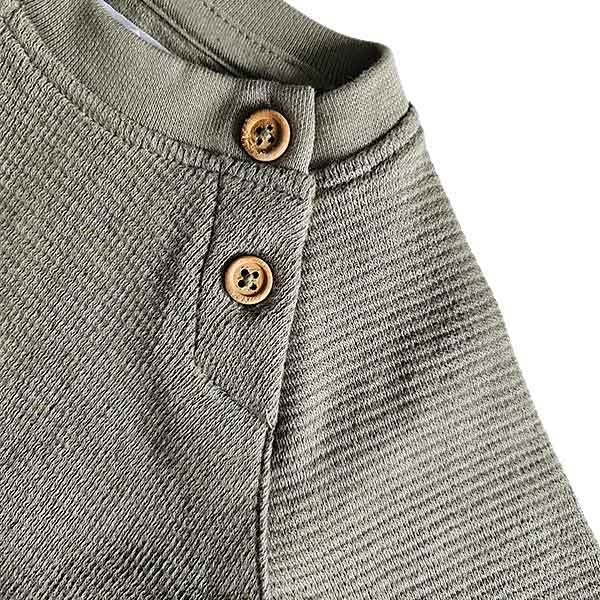 Groen baby shirtje voor jongens van Studio Spruitje met lange mouwen en houten knoopjes