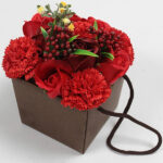 zeep bloemen boeket rode roos en anjer in luxe cadeauverpakking op tafel